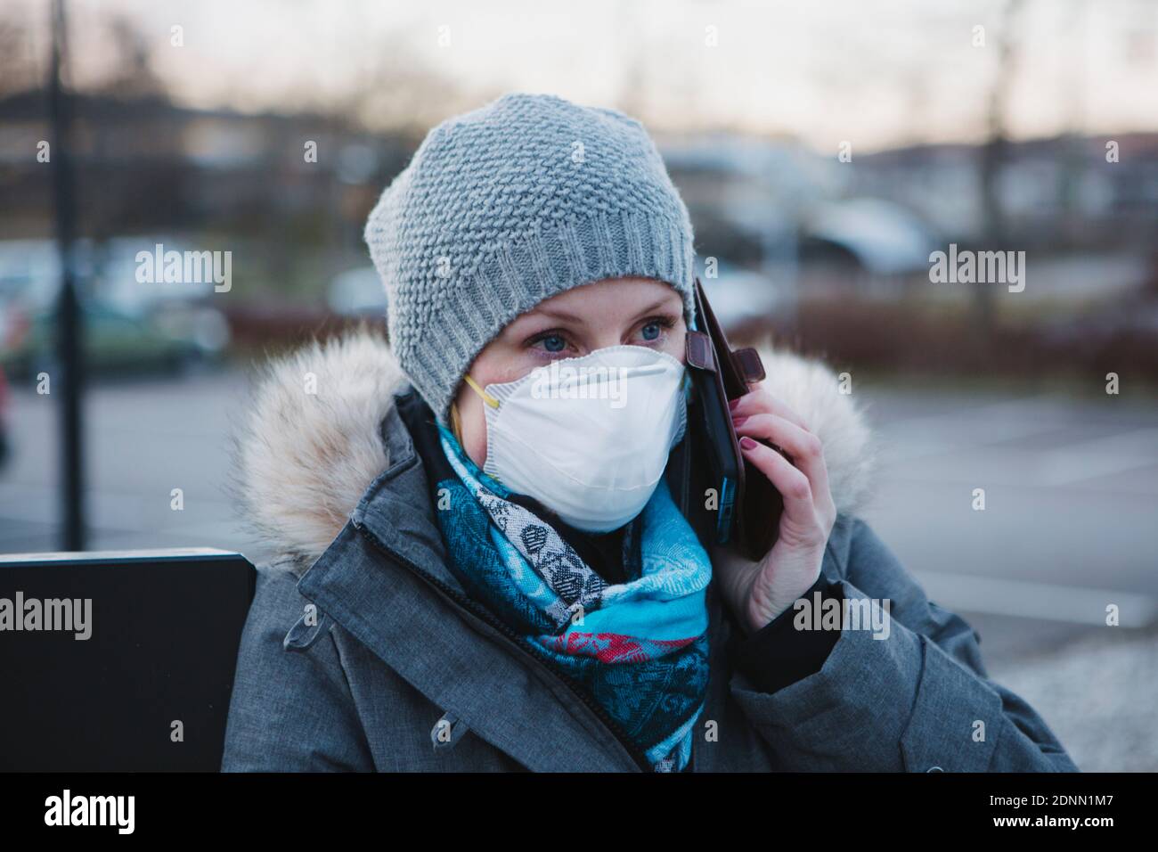 Woman wearing protective mask talking via cell phone Stock Photo