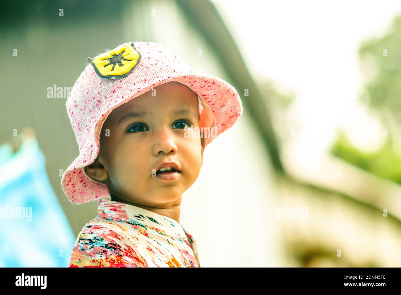 A boy wearing a soft pink color cap and shirt and looking cute and