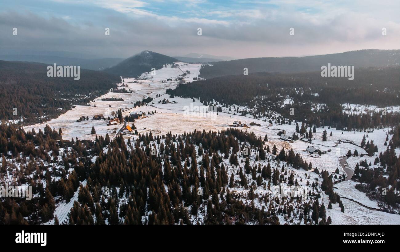 Winter aerial view of mountain landscape and large meadow at Jizerka settlement,Czech republic. Winter nature in cloudy day.Peat bogs of Jizerka.Snowy Stock Photo