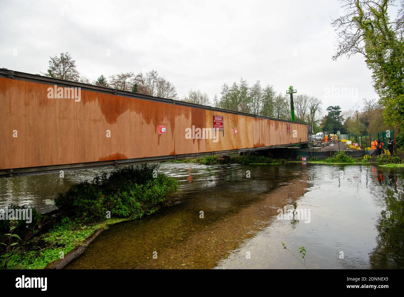 Denham, Buckinghamshire, UK. 9th December, 2020. Having already destroyed a big area of woodland, HS2 have now moved into place a temporary access bridge across the River Colne in Denham Country Park to enable heavy machinery into the irreplaceable wet woodlands and SSSI. HS2 Rebillion and environmental activists are living in tree houses high in ancient trees next to the bridge trying to save them from the destructive chain saws of HS2 Ltd. Credit: Maureen McLean/Alamy Stock Photo