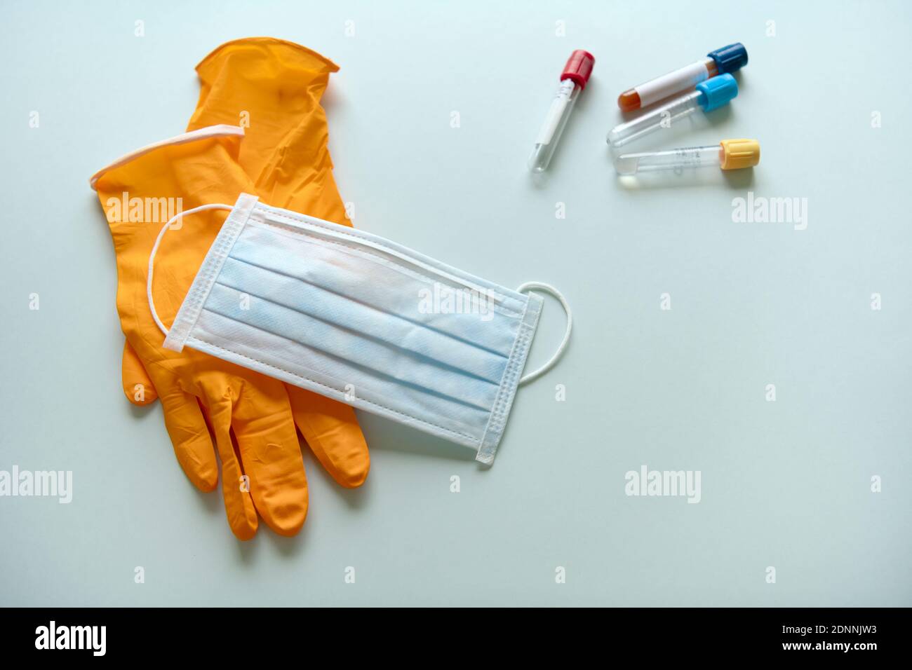 Surgical gloves, mask and test tubes on blue background Stock Photo - Alamy