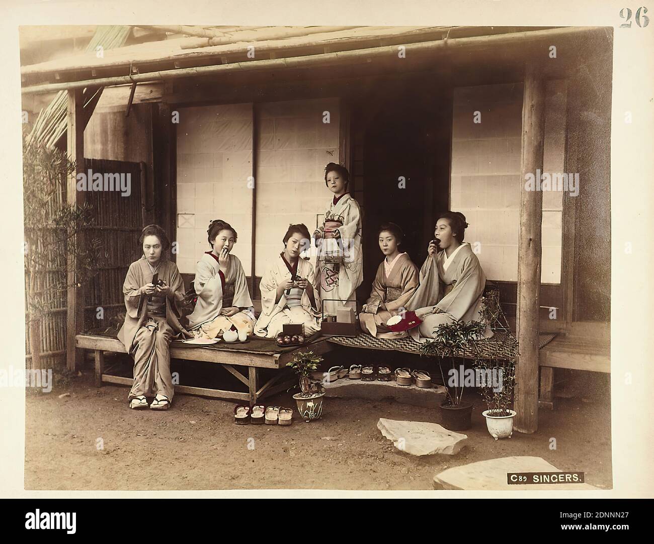 C89 Singers, albumin paper, black and white positive process, hand colored, image size: height: 21,40 cm; width: 27,40 cm, titled, C89 Singers, titled: recto o. r.: 26, travel photography, portrait photography, group portrait, residential house, storey house, woman, sitting figure, kneeling figure, standing figure, folk costume, regional costume Stock Photo