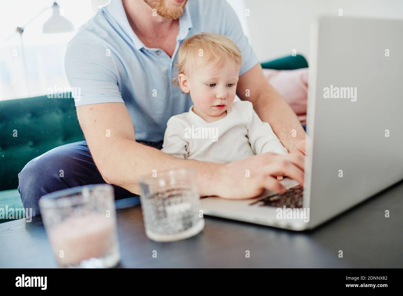 Father and toddler son using laptop Stock Photo