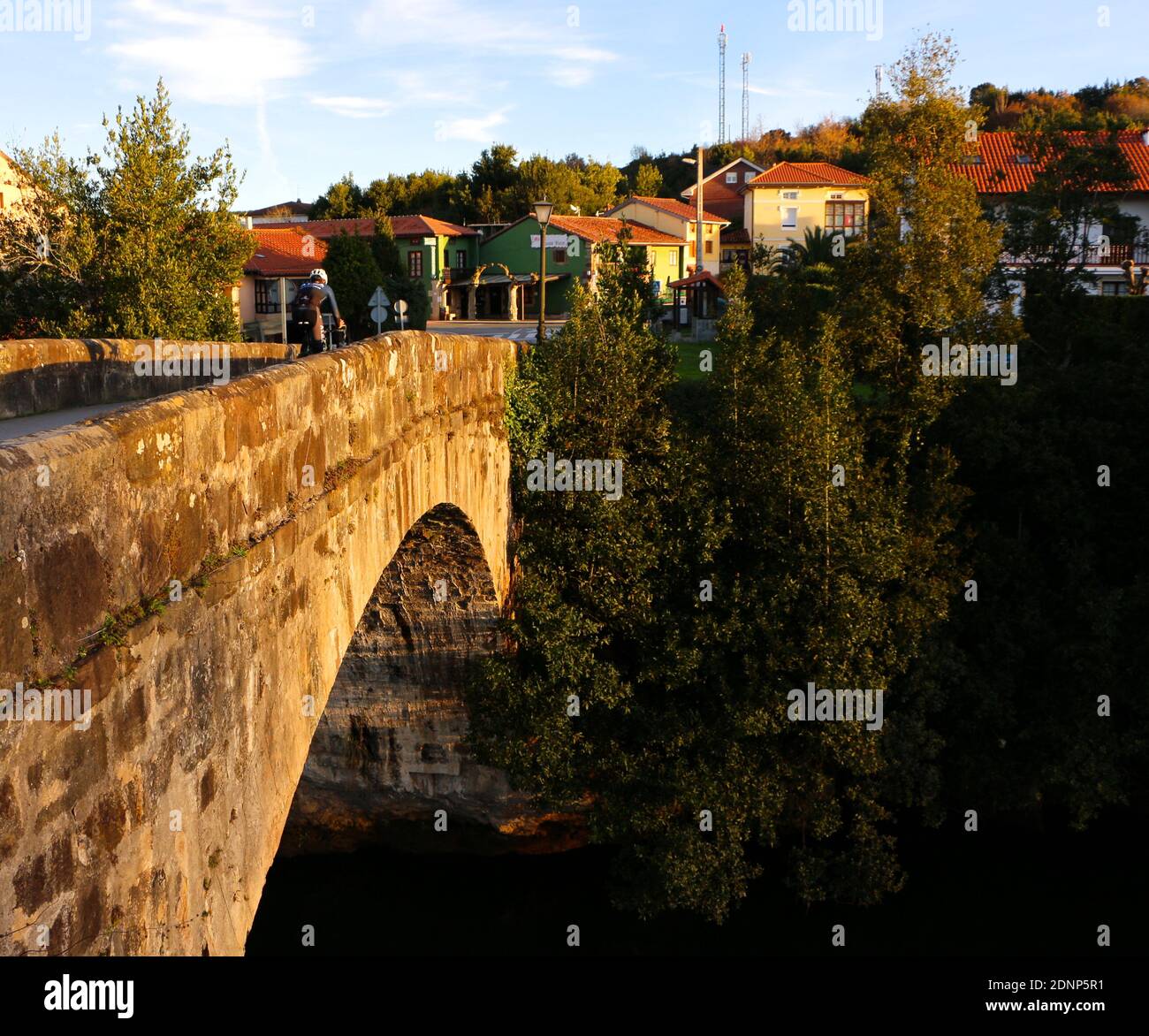 16th century Puente Viejo over the River Pas Puente Arce Cantabria Spain with a cyclist crossing early morning Stock Photo