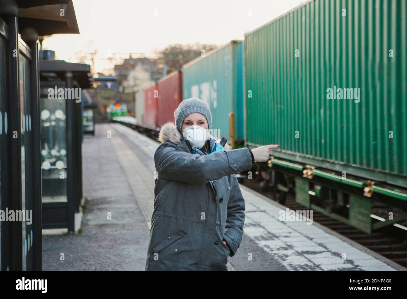Woman wearing protective mask on train station platform Stock Photo