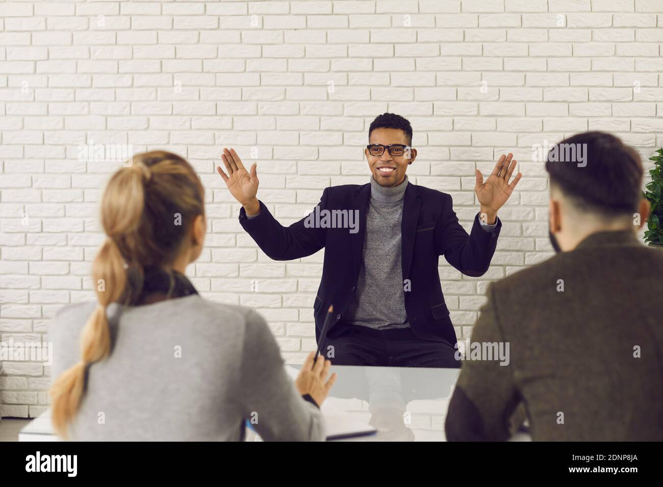 Charismatic candidate describing his work experience in job interview with HR managers Stock Photo