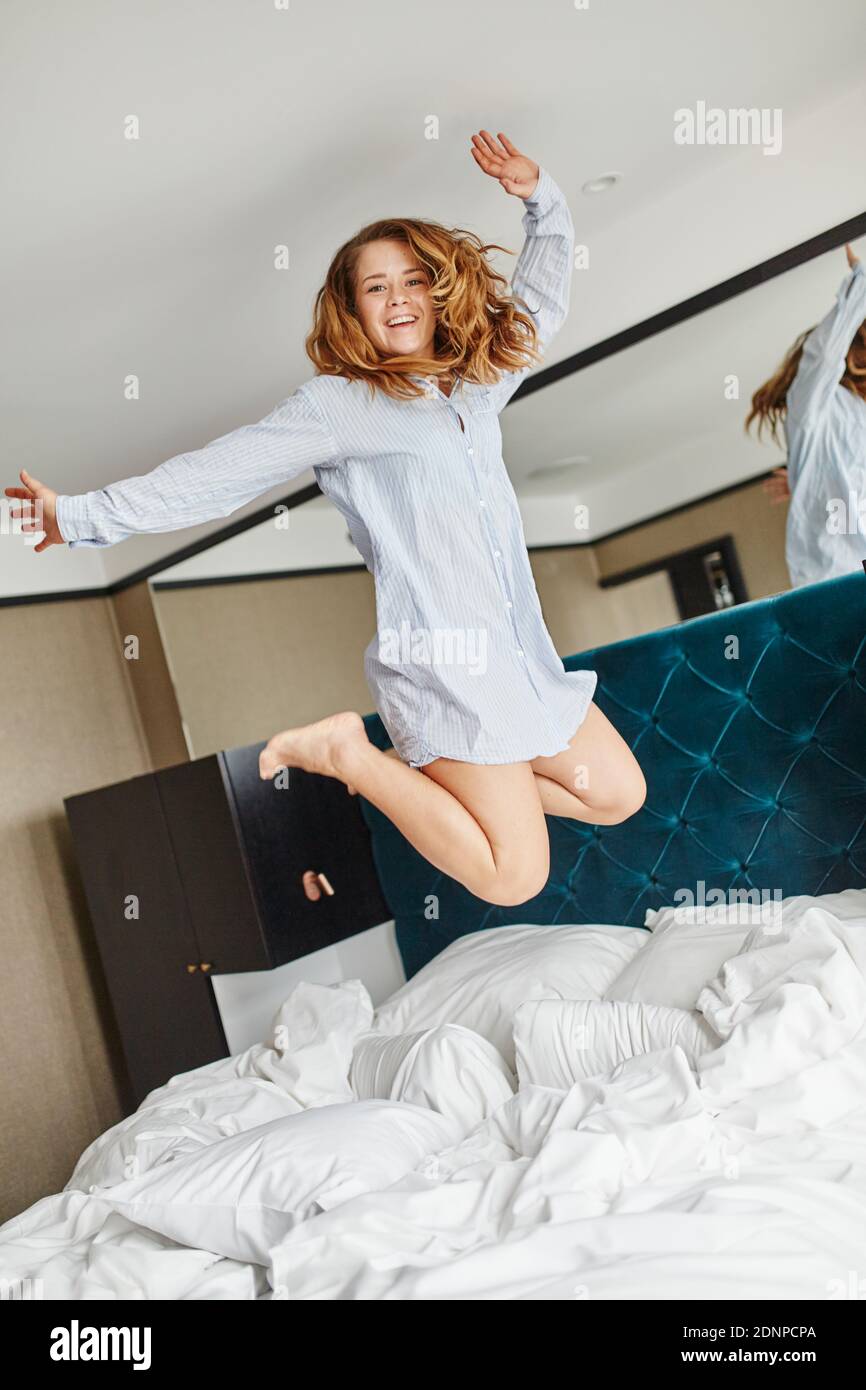 Woman jumping on bed Stock Photo Alamy