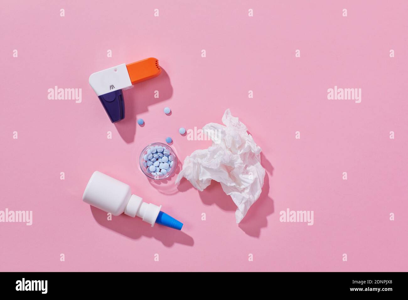 Inhaler and allergy medicine on pink background Stock Photo