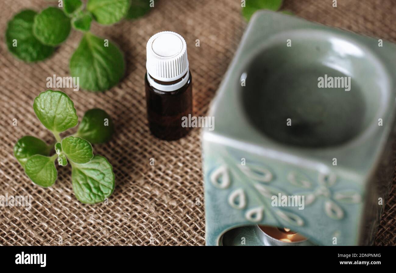 Close up of aroma lamp with burning candle and essential rhyme or plectranthus amboinicus oil