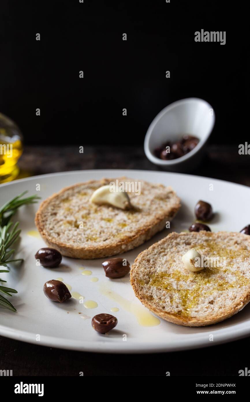 High Angle View Of Bread With Rosemary In Plate On Table Against Black Background Stock Photo
