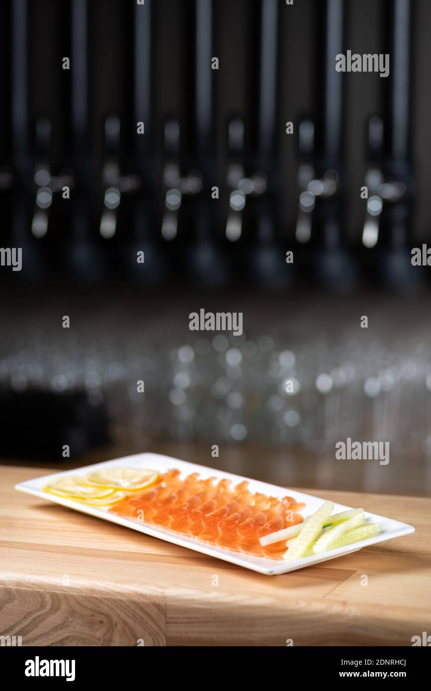 Restaurant menu. Plate with slightly salted and smoked salmon on wooden table background. Copy space. Menu for beer in restaurant Stock Photo