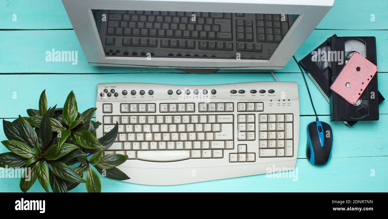 Retro computer on blue wooden table. Monitor, keyboard, pc mouse, pot ...