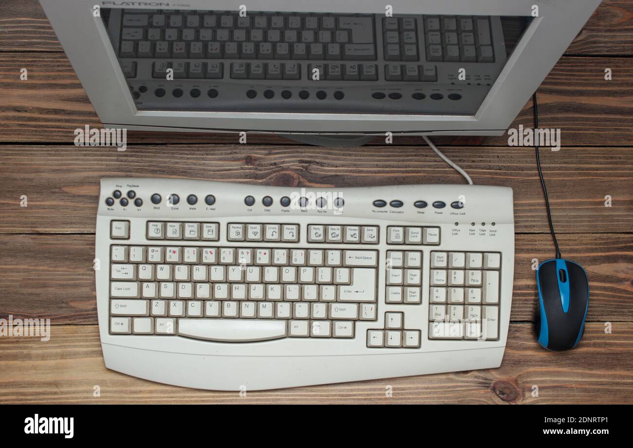 Retro computer on wooden table. Monitor, keyboard, pc mouse, top view Stock Photo