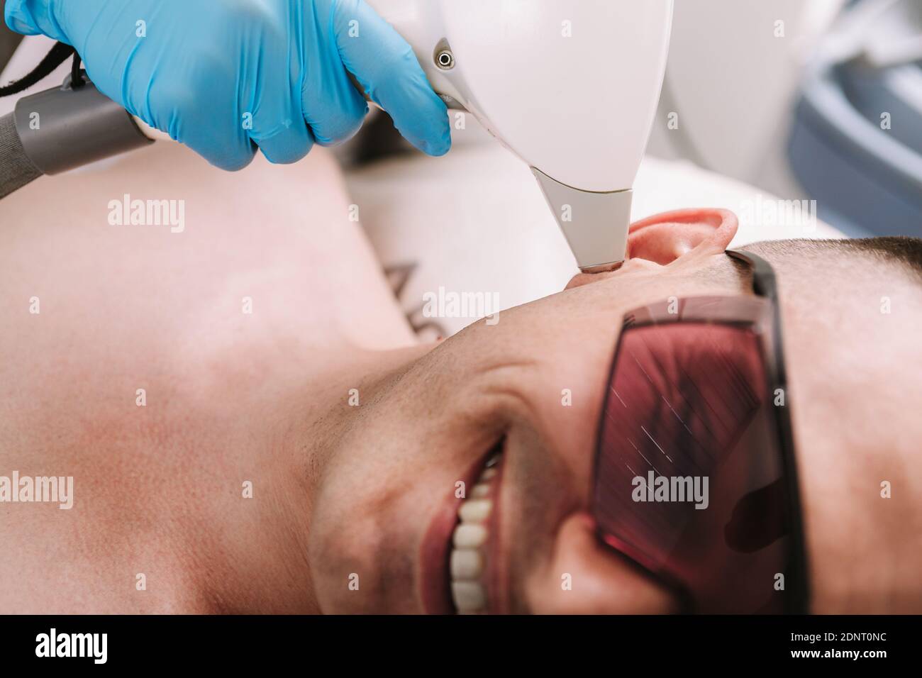Cropped Close Up Of A Man Smiling Getting Laser Hair Removal Treatment On His Ear Beautician Removing Hair On The Ear Of A Male Client Using Laser Stock Photo Alamy