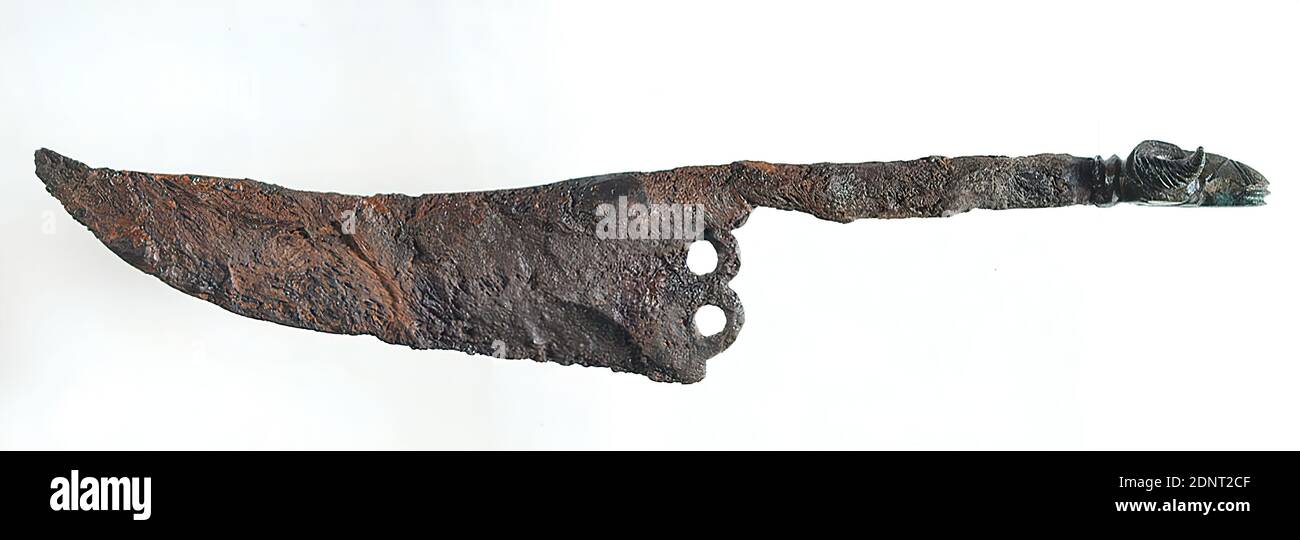 Knife, Bronze, iron, cast, chased, bronze, iron, Total: Height: 2,8 cm; Width: 15,9 cm; Width: 7 cm (handle), tools, ram (animal), animals as ornament, Early Imperial Period, Augustus, Tiberius, The knife made of iron with a wide blade, bulging at the front, was provided with a bronze ram head at the end of the handle. The large, winding horns are striking. The knife served as a burial object and was laid down in a Roman cauldron found during excavations by Gustav Schwantes around or before 1914 in the necropolis of Nienbüttel (district of Uelzen). Stock Photo