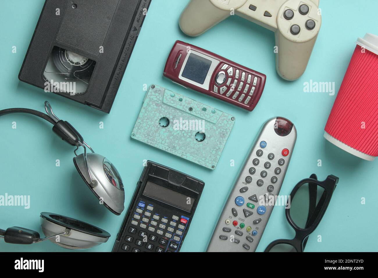 Retro objects on blue background. 3d glasses, audio cassette, video cassette, gamepad,calculator, tv remote, headphones, push-button phone. Analog med Stock Photo