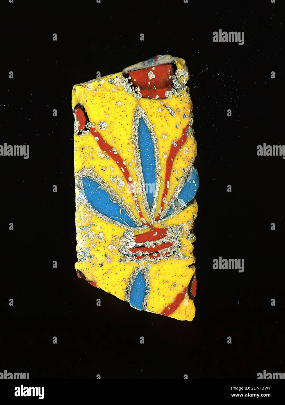 Mosaic glass fragment, glass, millefiori technique, Total: Height: 3.80 cm; Width: 1.80 cm, Floor coverings, wall decorations, floral ornaments, Early Imperial Period, The small, almost rectangular glass fragment shows a flower on a yellow background, whose elongated blue sepals and red stamens emerge from a red rectangle. An already heavily corroded strip of glass surrounds the leaves. In Roman times, colored, ornamented glass was used for vessels, mosaics, wall decorations and furniture ornaments. For the production different colored glass was formed into tubes and rods. Stock Photo