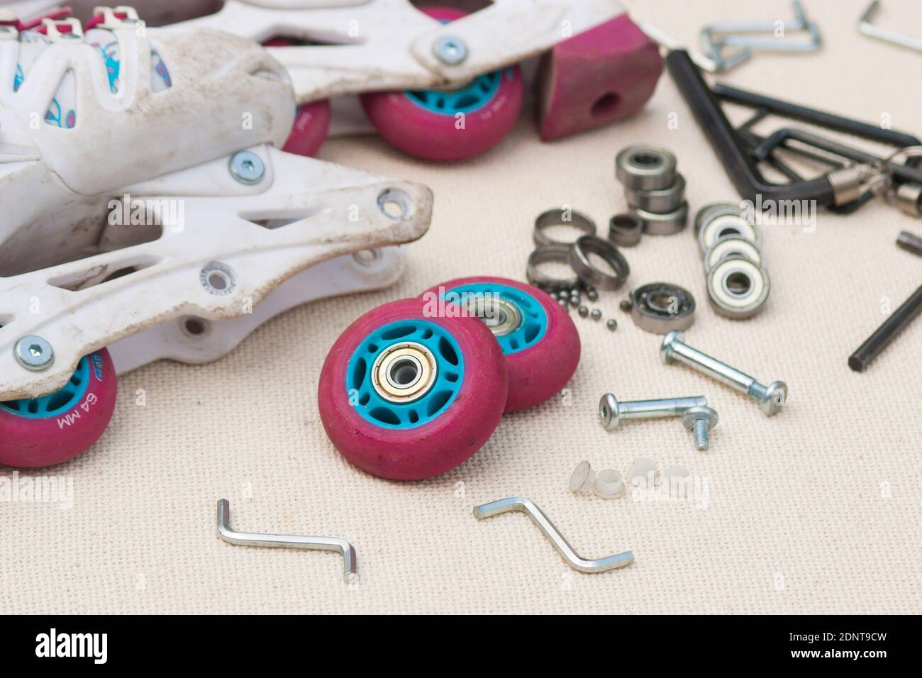 Roller skate bearing replacement. Disassembled roller skates, new and worn bearings, axles