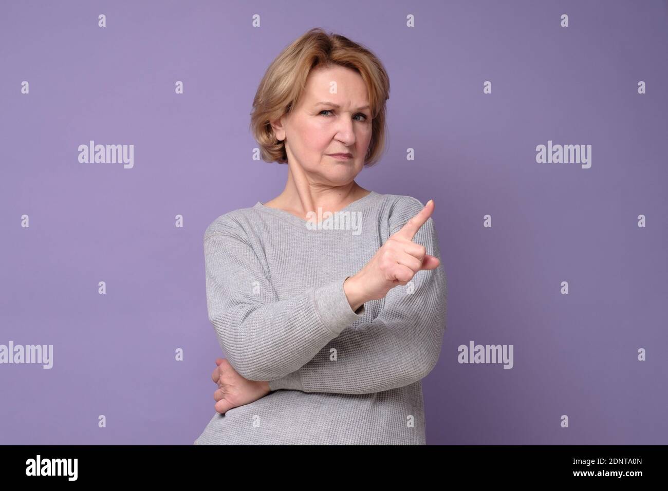Senior woman with rejection expression doing negative sign saying no. Studio shot Stock Photo