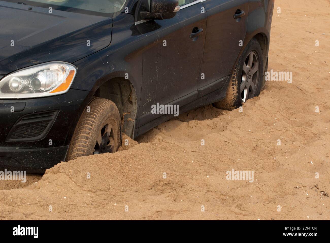 Car stuck in the sand. A black passenger car stalled on a sandy surface