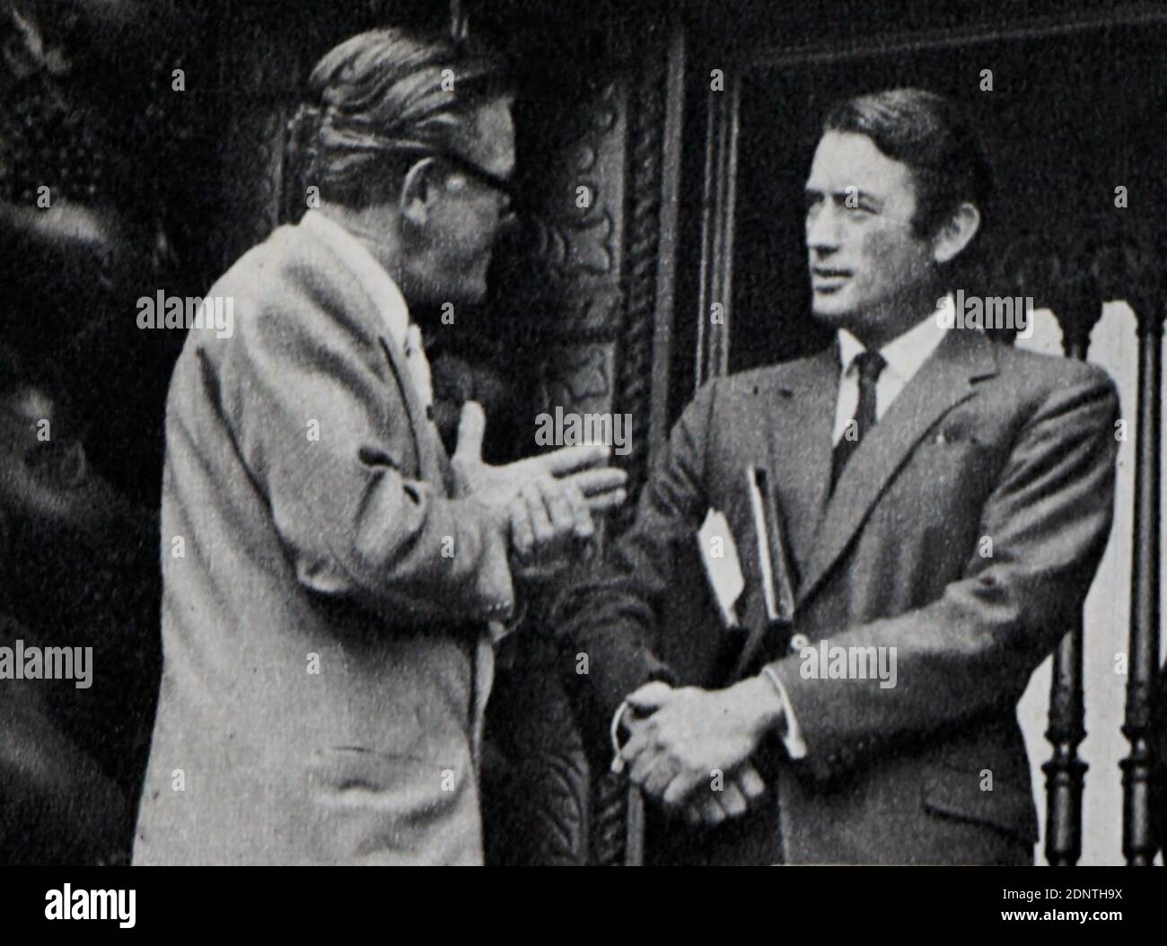 Photograph of Gregory Peck (1916-2003) talking with Earl St. John (1892-1968). Stock Photo