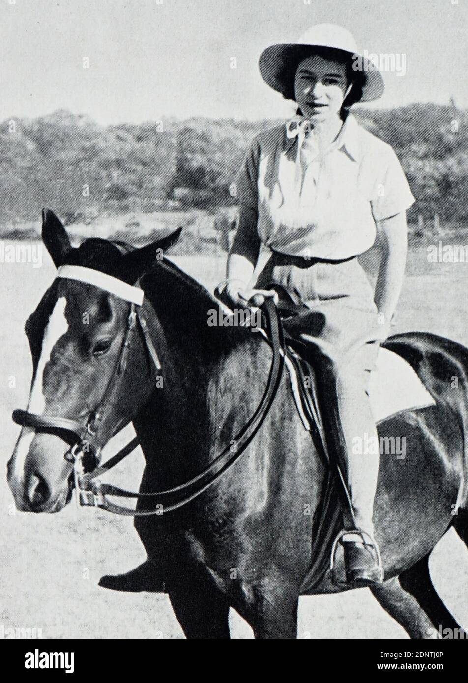 Photograph of Queen Elizabeth II riding a horse on Bonza Bay Beach, South Africa. Stock Photo