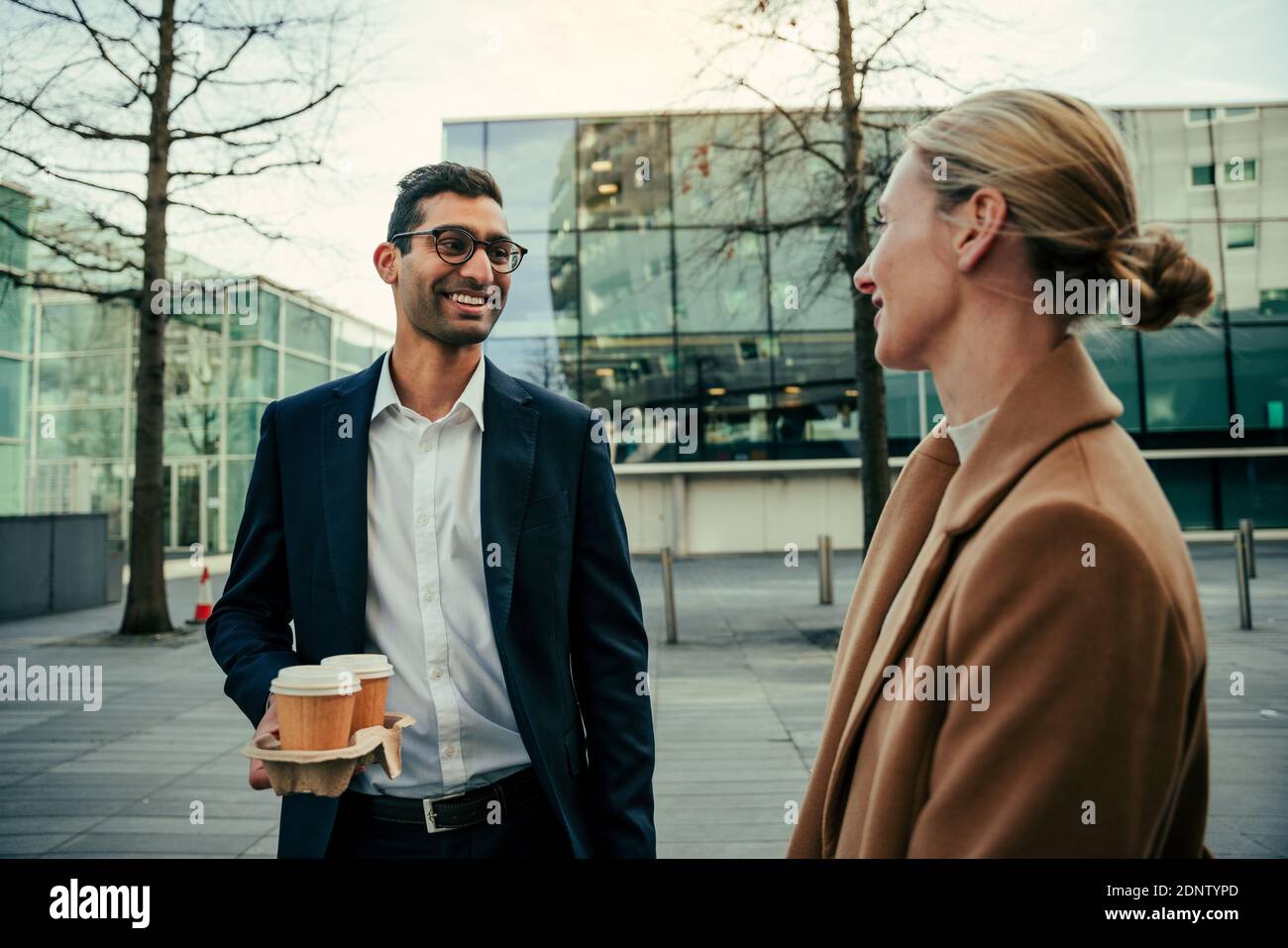 young mixed race gentlemen buys coffee for beautiful caucasian woman smiling  Stock Photo