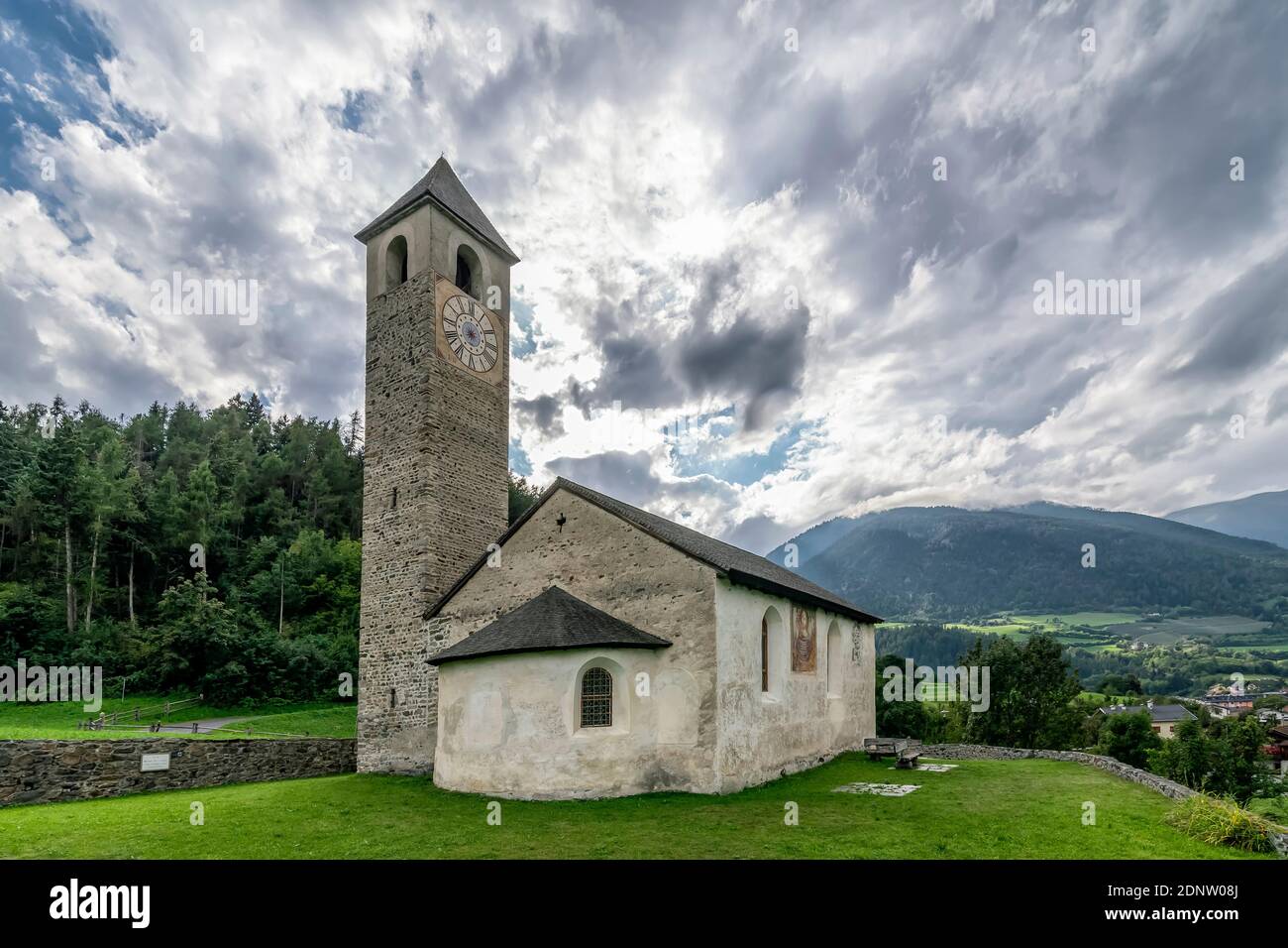 The ancient Church of San Giovanni in Prato allo Stelvio, South Tyrol, Italy, under a dramatic sky Stock Photo