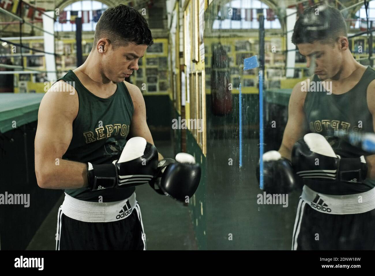 Young athletic man preparing for boxing competitions, training defense