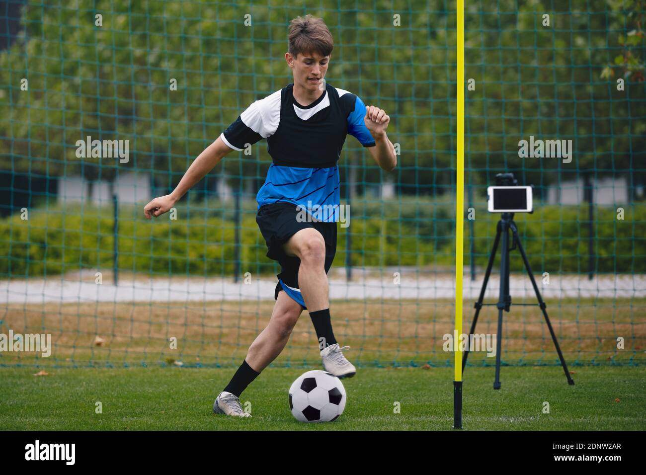 Young Football Soccer Player on Training With New Technology. New Technology in Soccer Training. Sports Athlete Running Ball. Tablet Device in the Bac Stock Photo