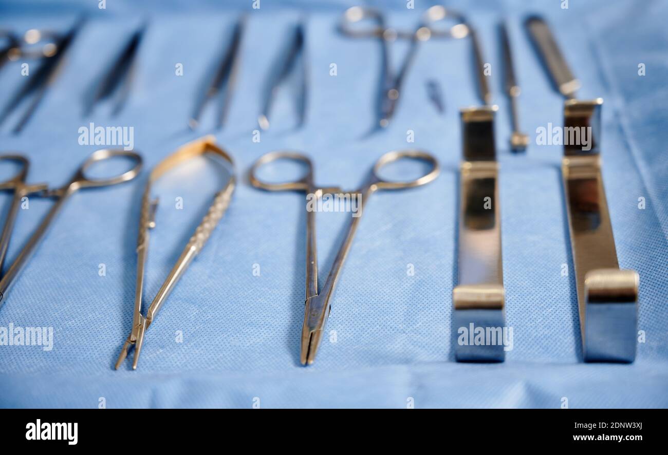 Various stainless steel tools for plastic surgery on blue medical cloth