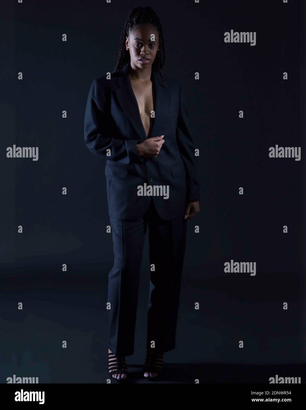Portrait Of Businesswoman Wearing Suit Standing Over Black Background Stock Photo