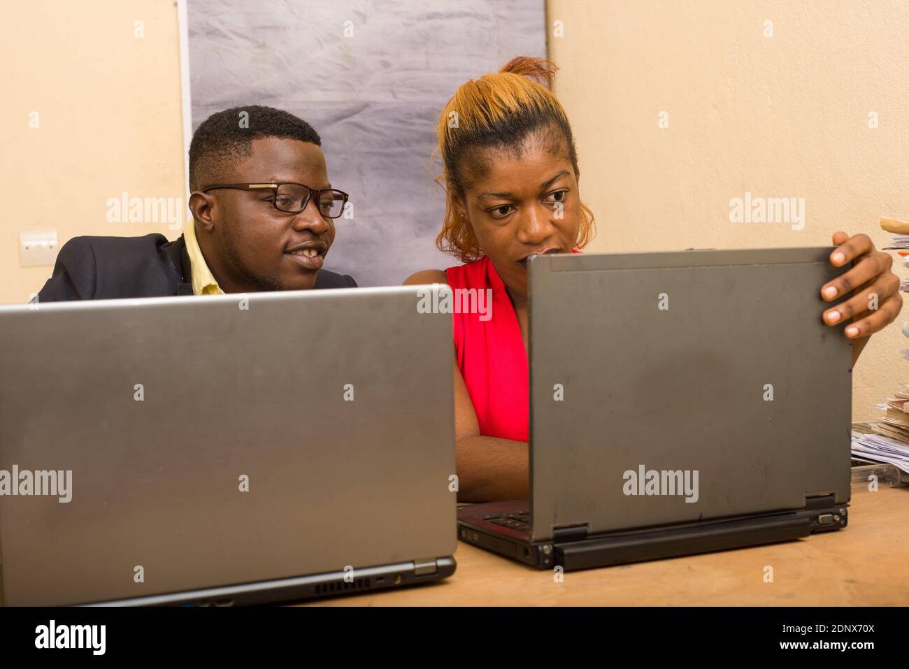 Teamwork: businessman and businesswoman working in office, they discuss and work on laptop. Stock Photo