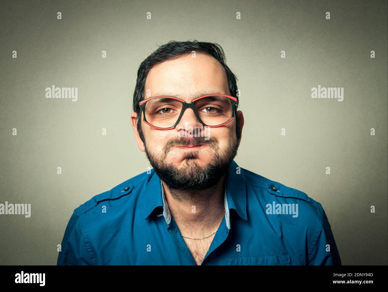 Portrait Of Mid Adult Man With Puffed Cheeks Against Gray Background Stock Photo
