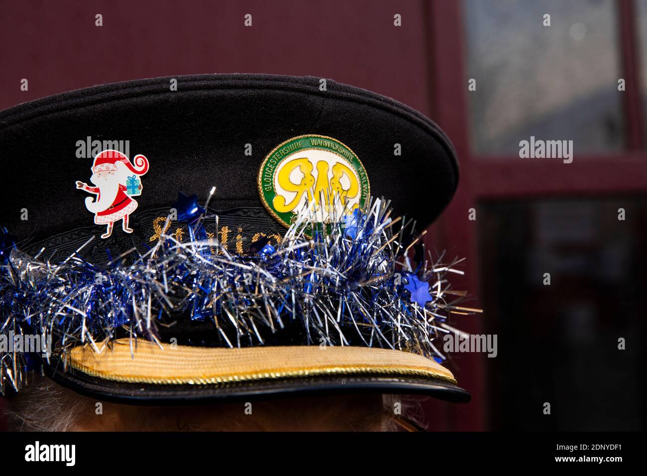UK, Gloucestershire, Toddington Station, Gloucestershire & Warwickshire Railway Santa Experience, Christmas tinsel on ticket collector’s hat Stock Photo