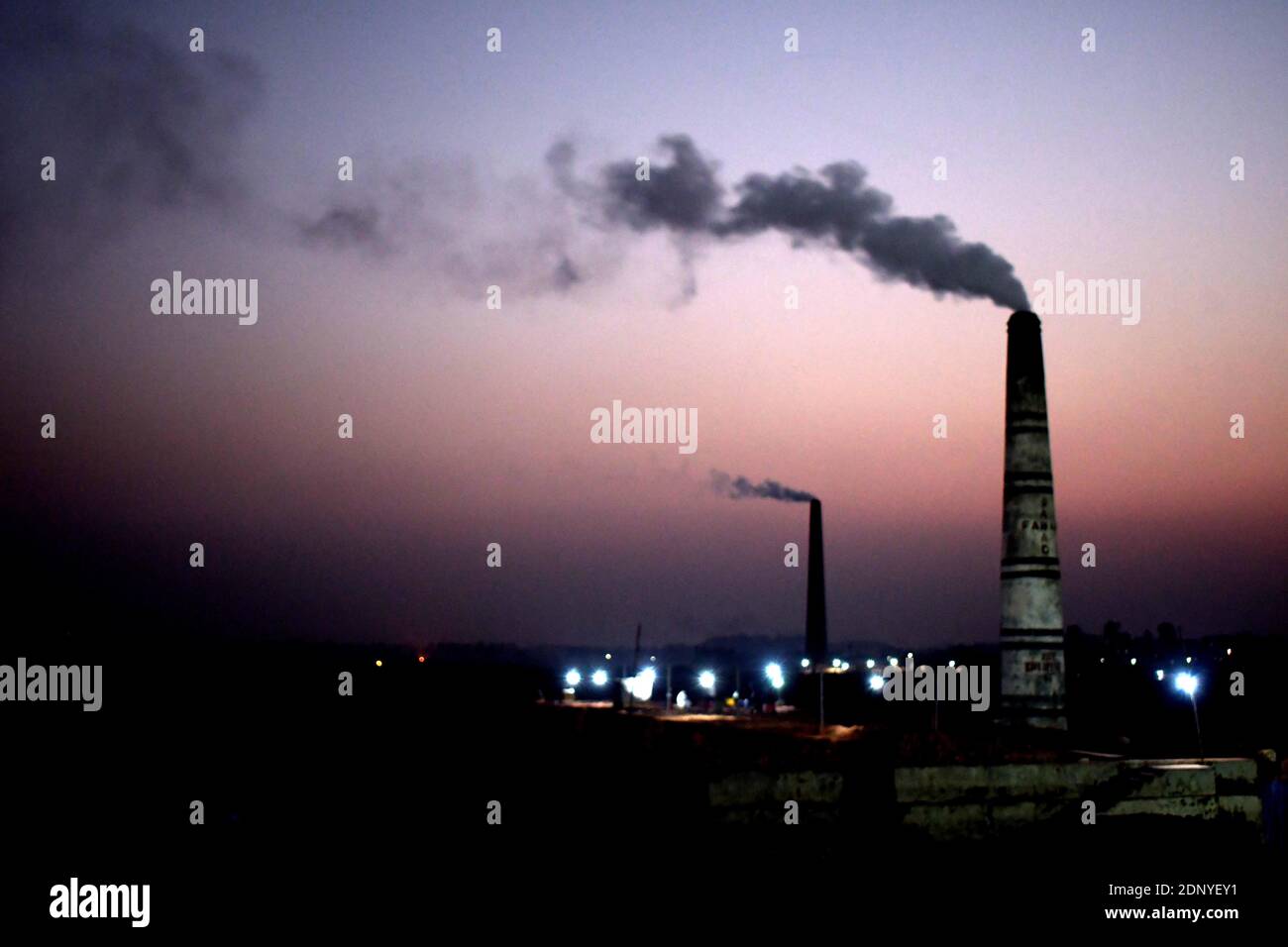 DHAKA, BANGLADESH – December 18, 2020: Air pollution, the chimney of a brick factory discharges smoke at the brick filed in Amin bazar, saver Dhaka. S Stock Photo