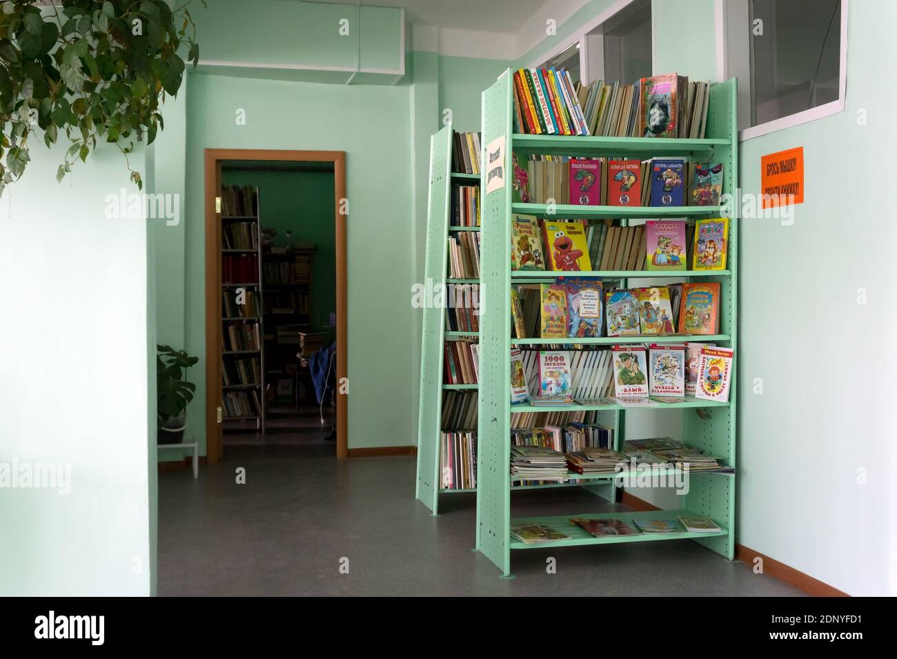 Shelves with children's books are in the village library. Stock Photo