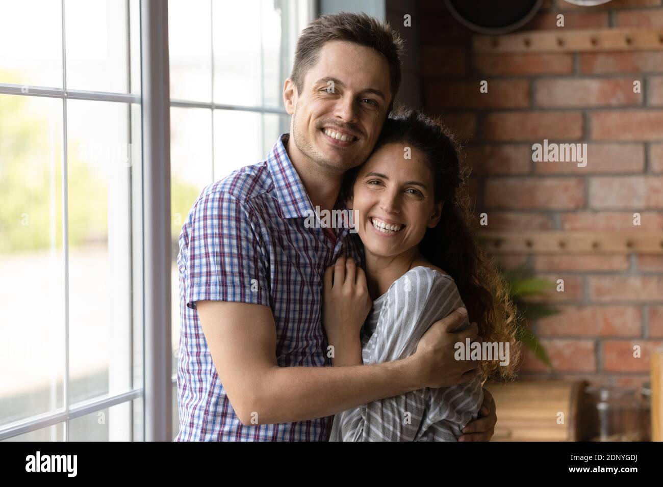 Happy married millennial couple embracing with love at new home Stock Photo