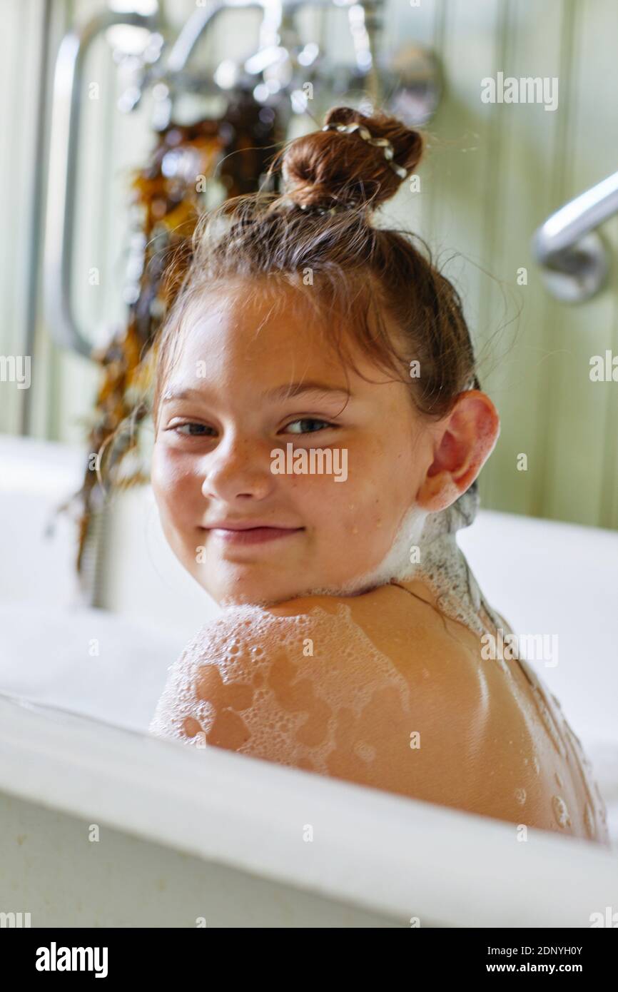 Smiling girl in bathtub looking at camera Stock Photo