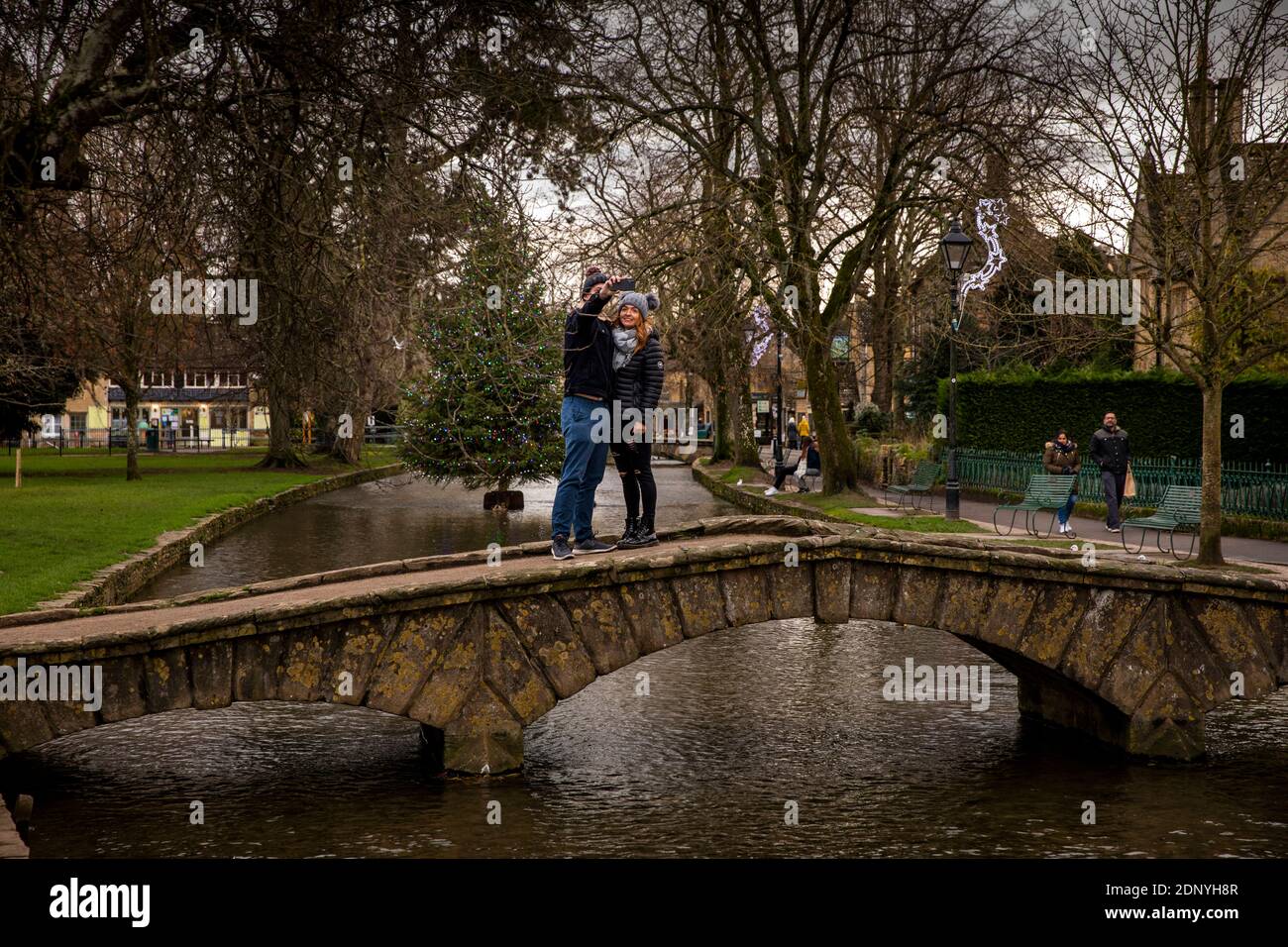 UK, Gloucestershire, Bourton on the Water, couple on bridge taking