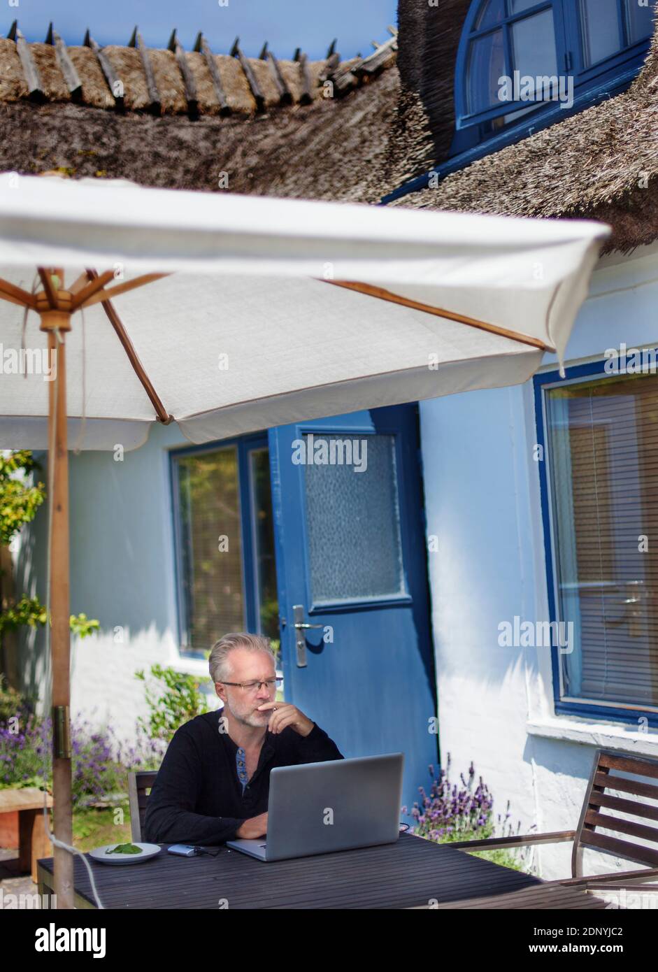 Man using laptop in garden Stock Photo