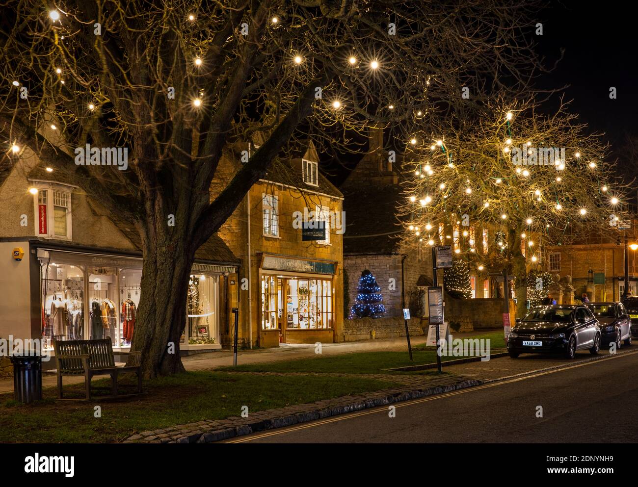 UK, Gloucestershire, Broadway, High Street, illuminated for Christmas late night shopping evening Stock Photo