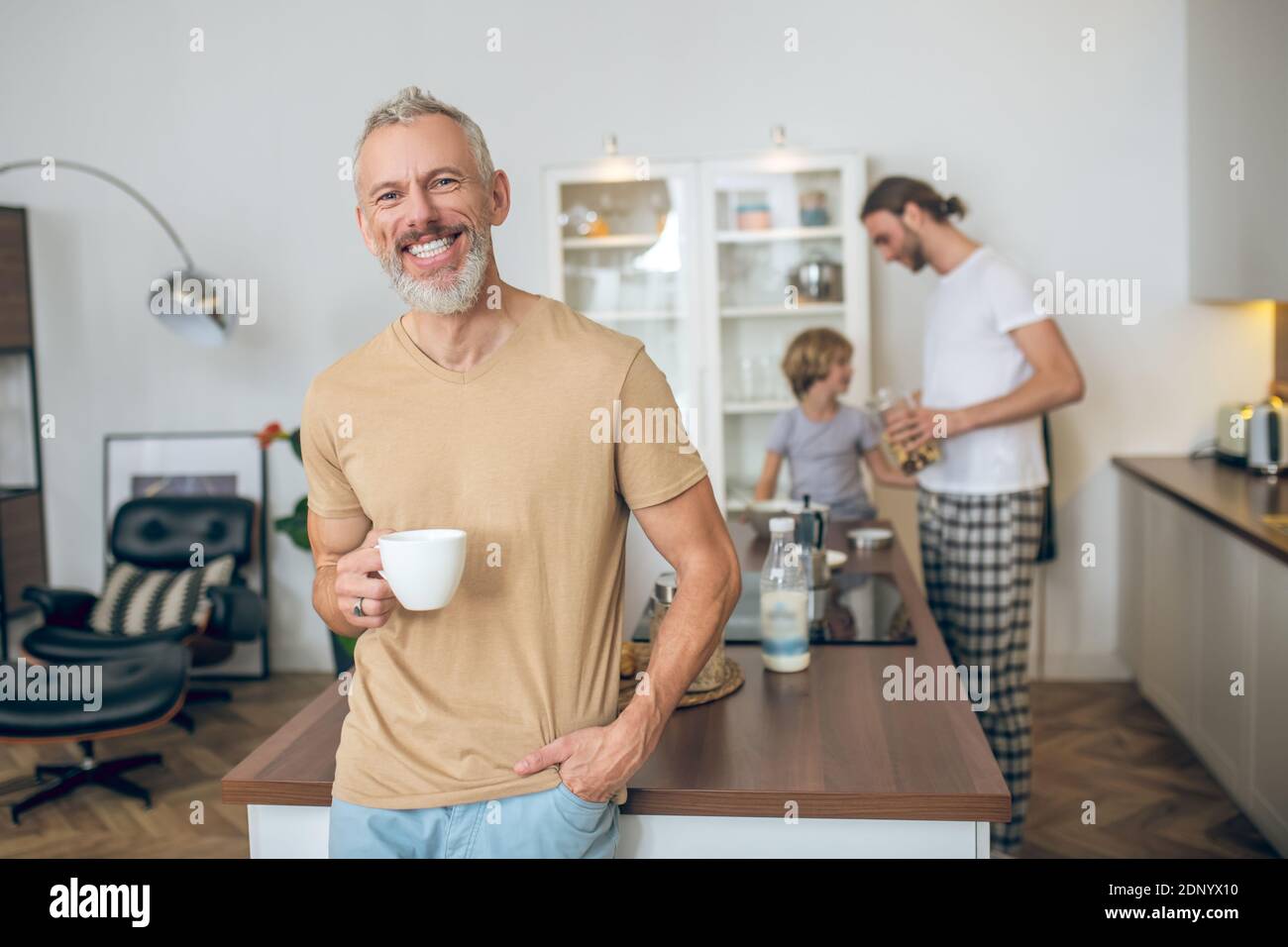 Grey-haired man having morning coffee and feeling good Stock Photo