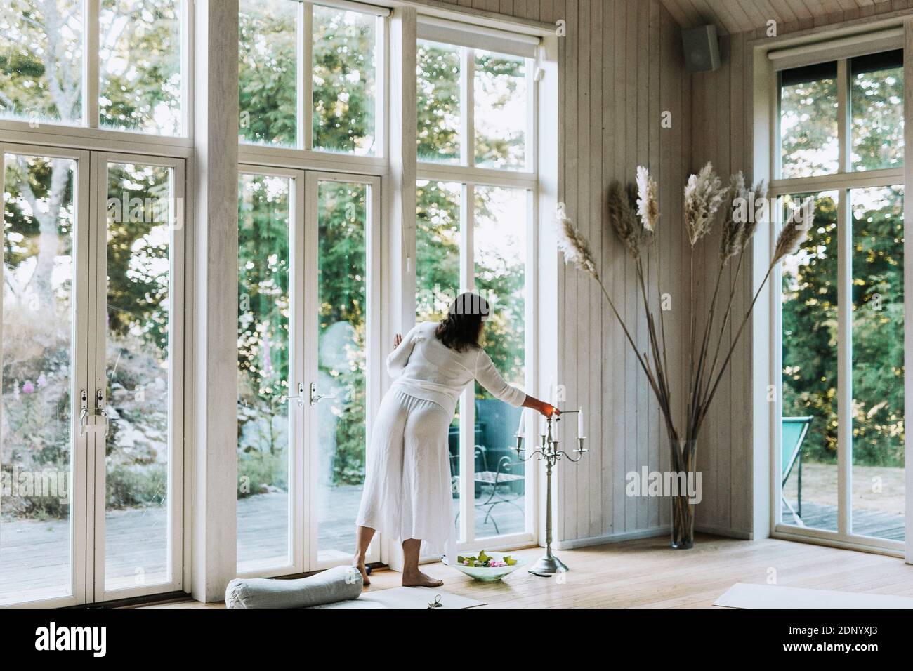 Woman lighting candles in yoga studio Stock Photo Alamy