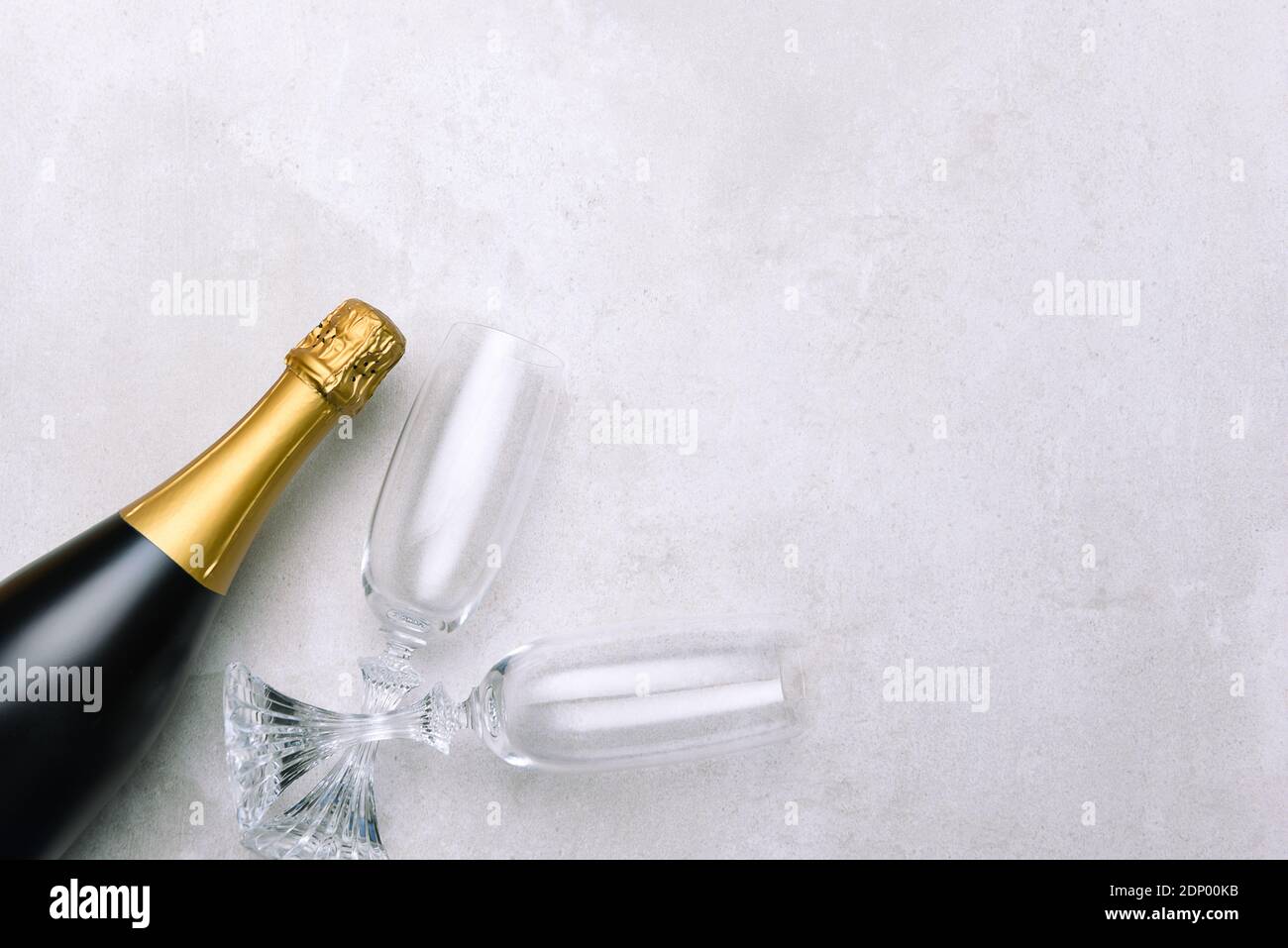 Champagne bottle and glasses on light gray surface. Horizontal format with copy space. Stock Photo