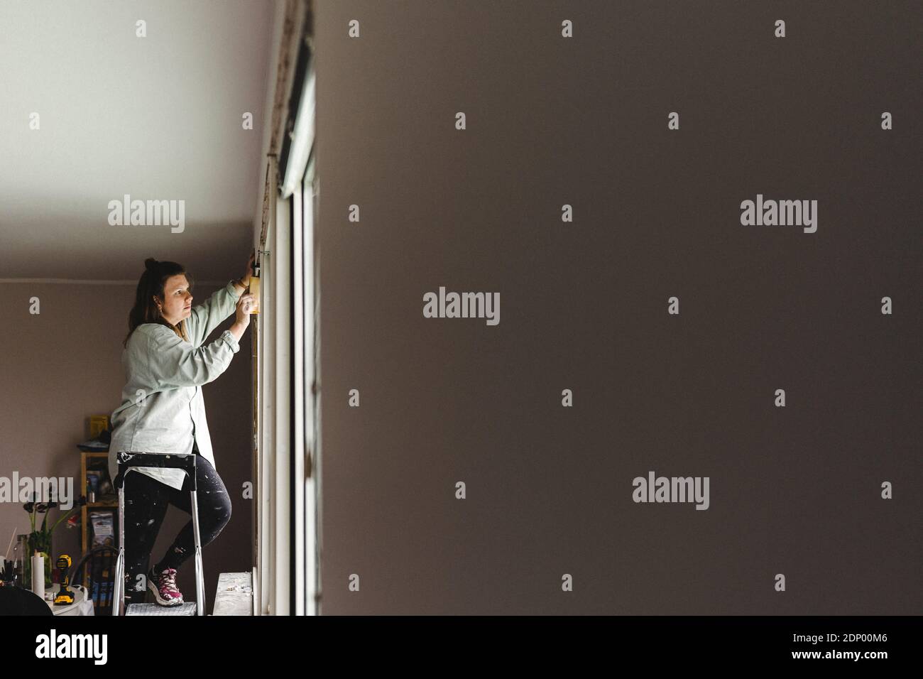 Woman sanding window frame Stock Photo Alamy