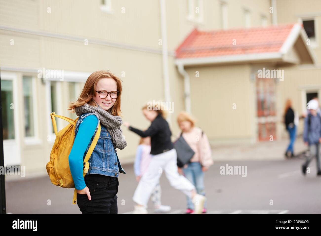 Smiling girl in front of school building Stock Photo - Alamy