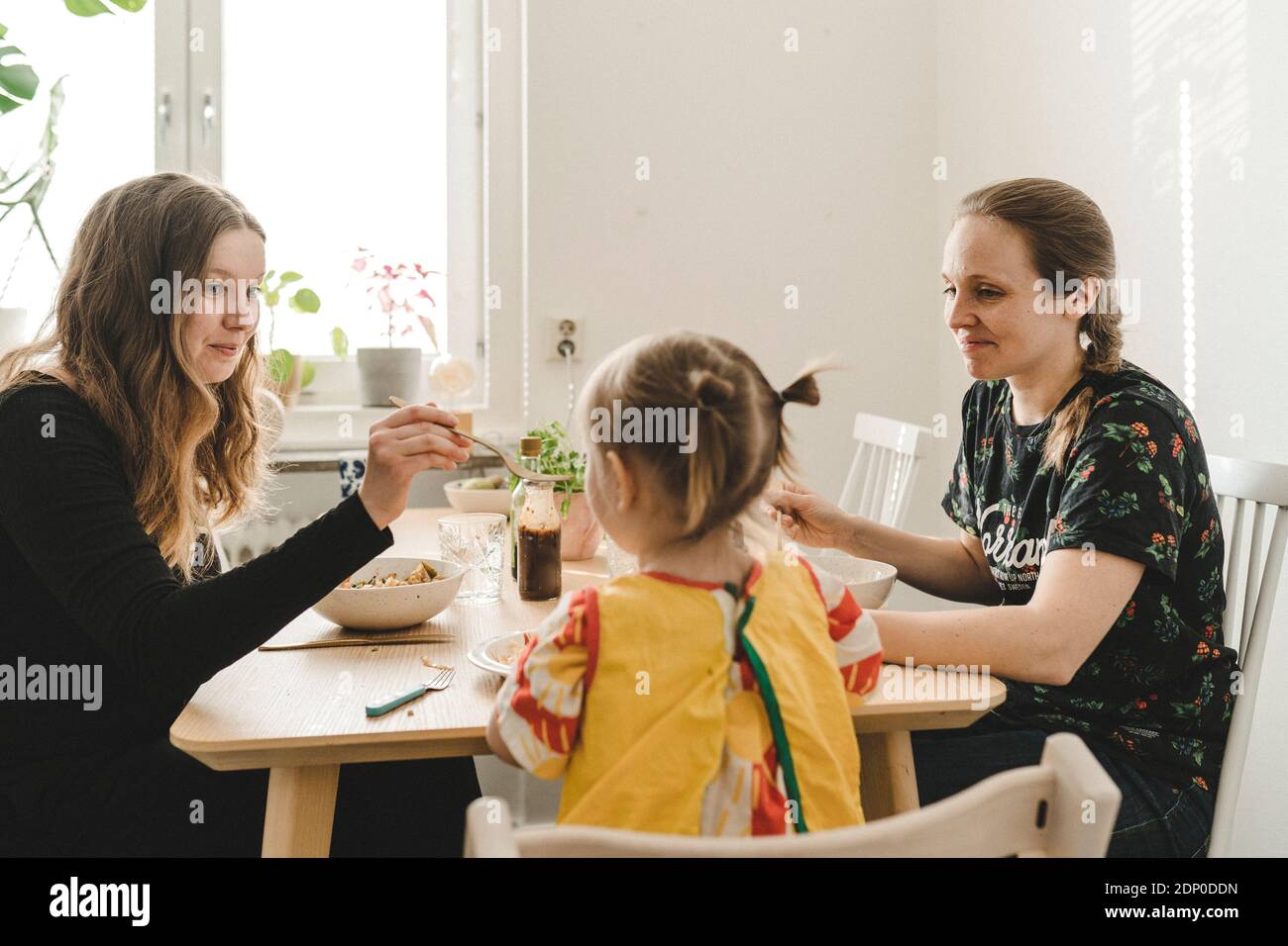 Family with daughter sitting at table Stock Photo