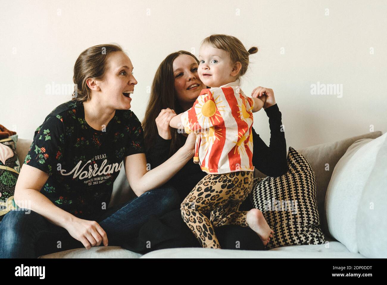 Girl with mothers on sofa Stock Photo