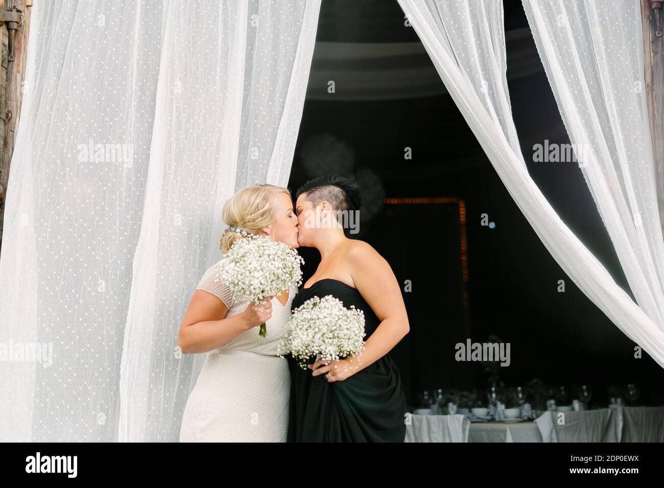 Brides kissing at wedding Stock Photo